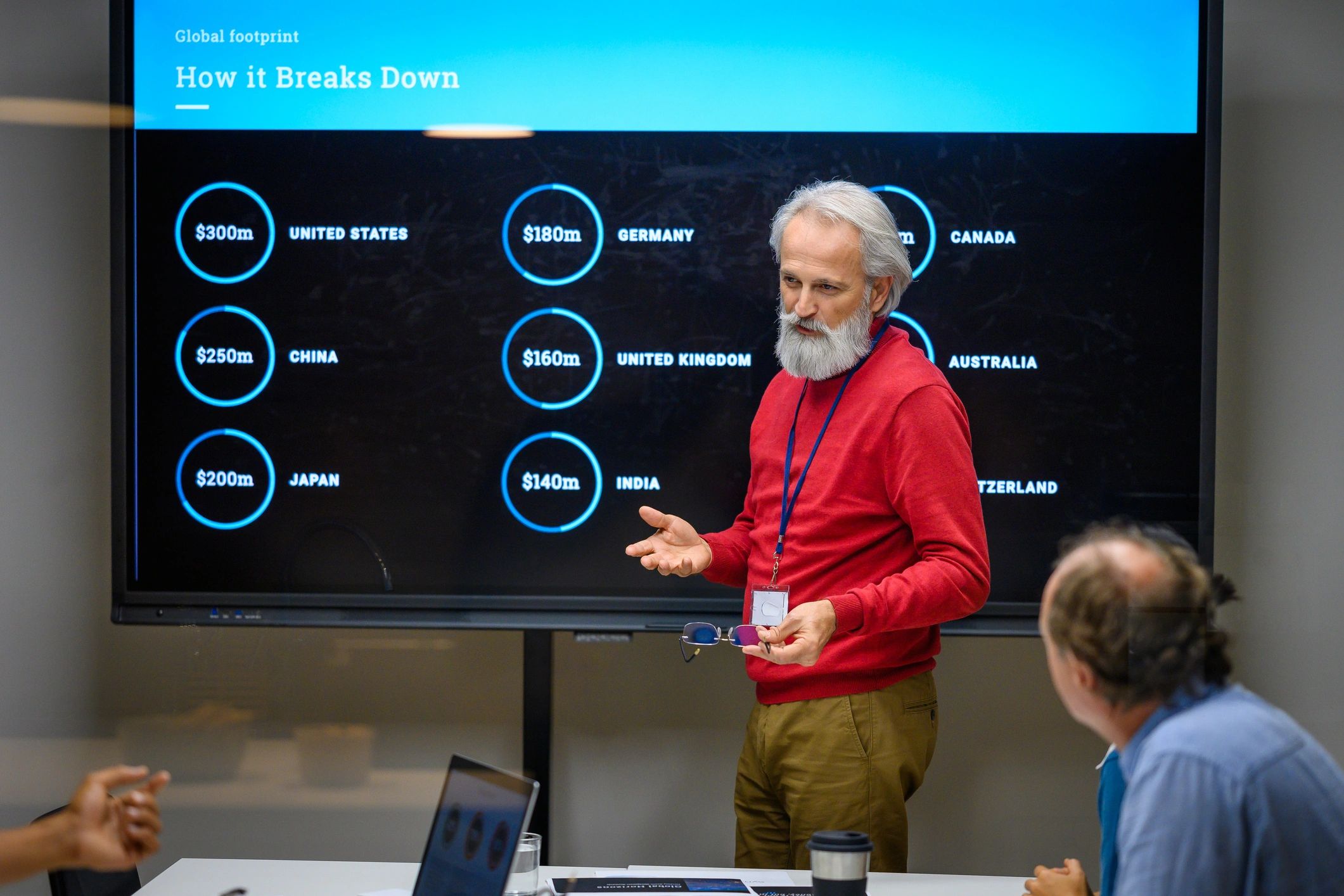Presenter pointing to a large screen in a meeting room
